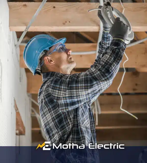 Motha Electrician working on electrical wiring during a remodeling project in Middlesex County, MA.